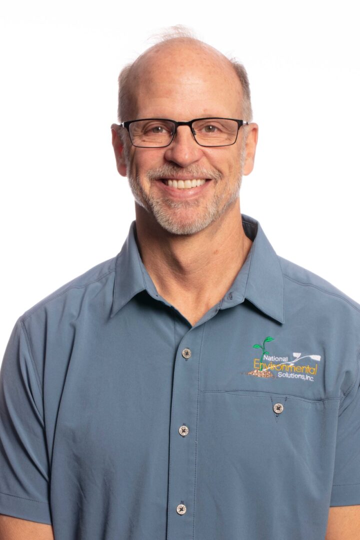 A man wearing glasses and a blue shirt.