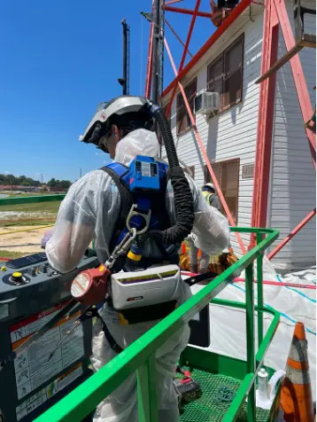 A man in safety gear working on a building.