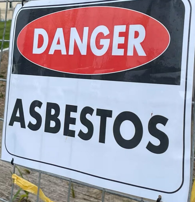 A sign warning of asbestos in the background.